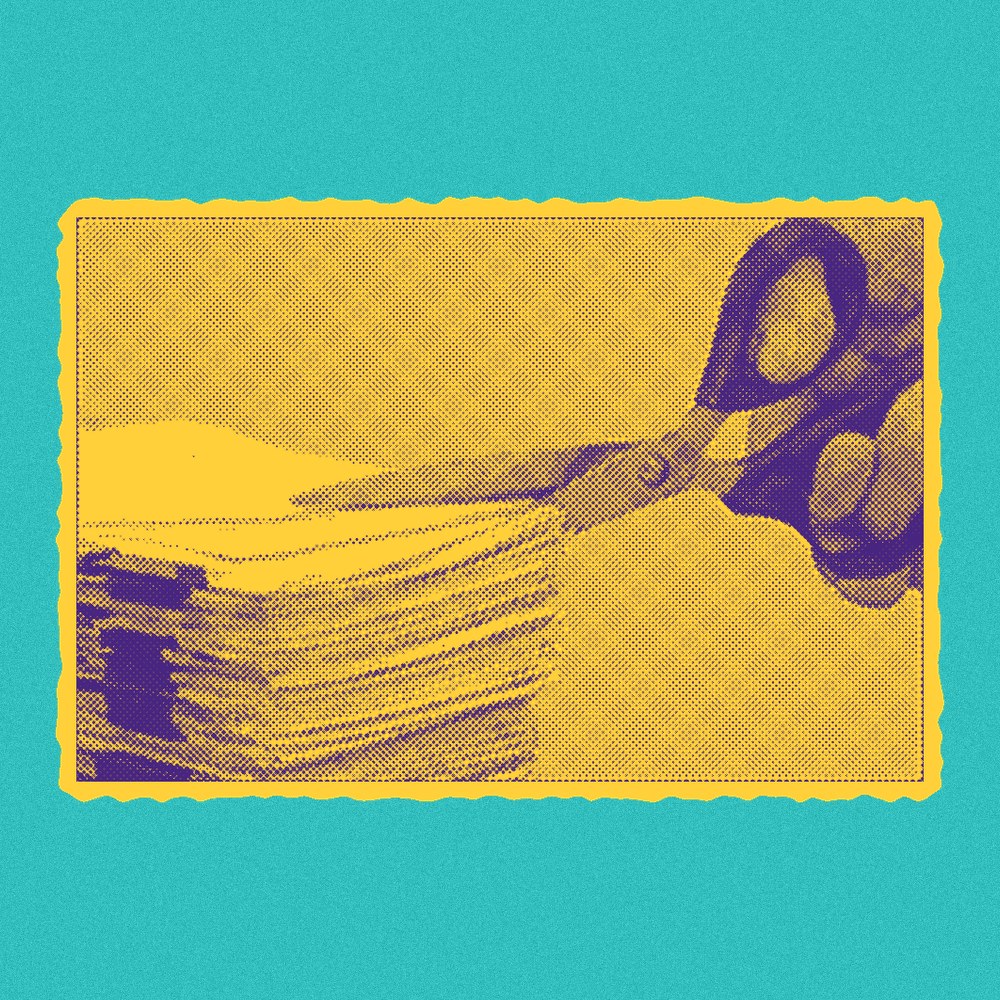Newsprint clipping of scissors cutting through paperwork.
